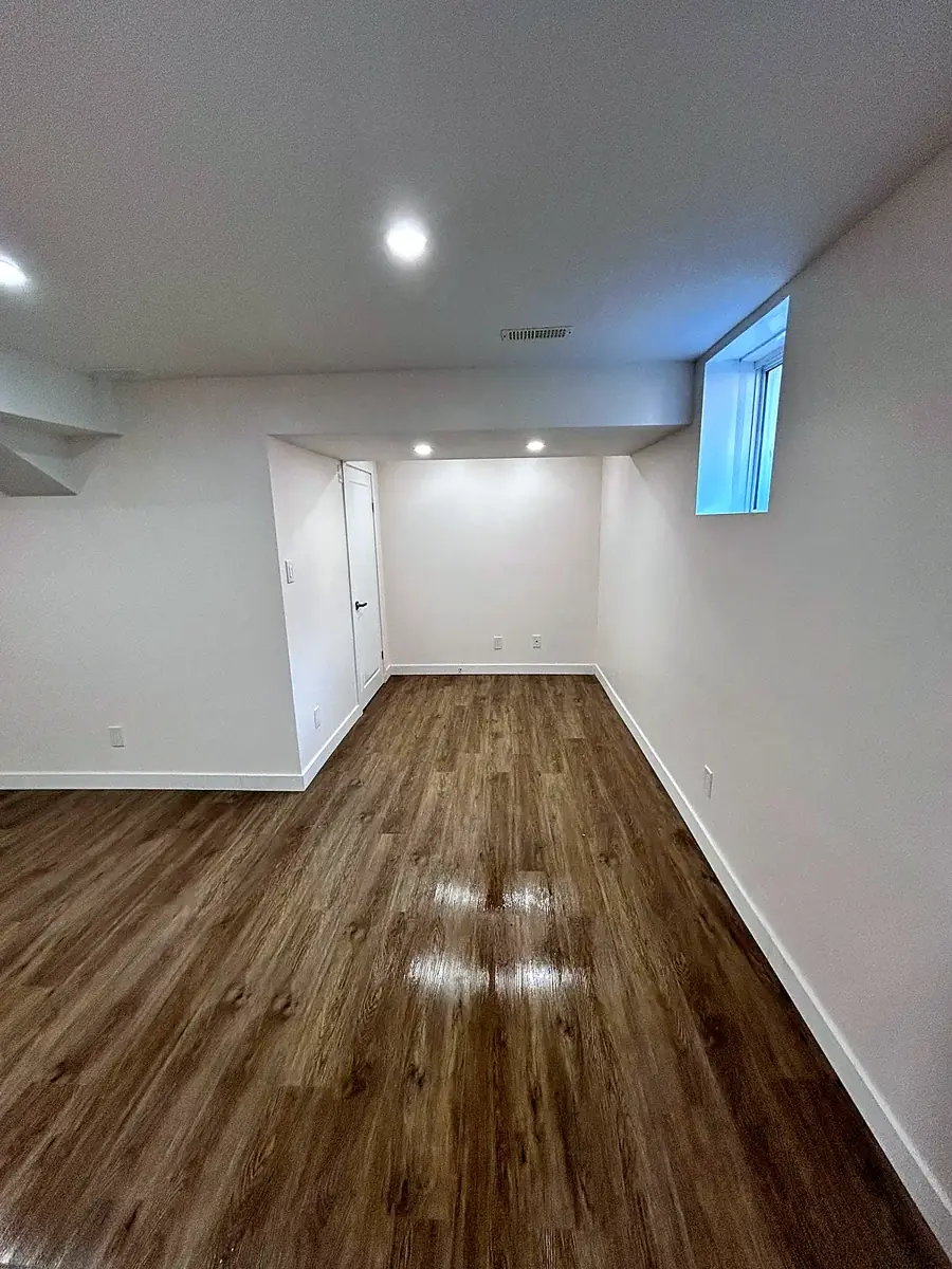 Basement room with egress window and pot lights